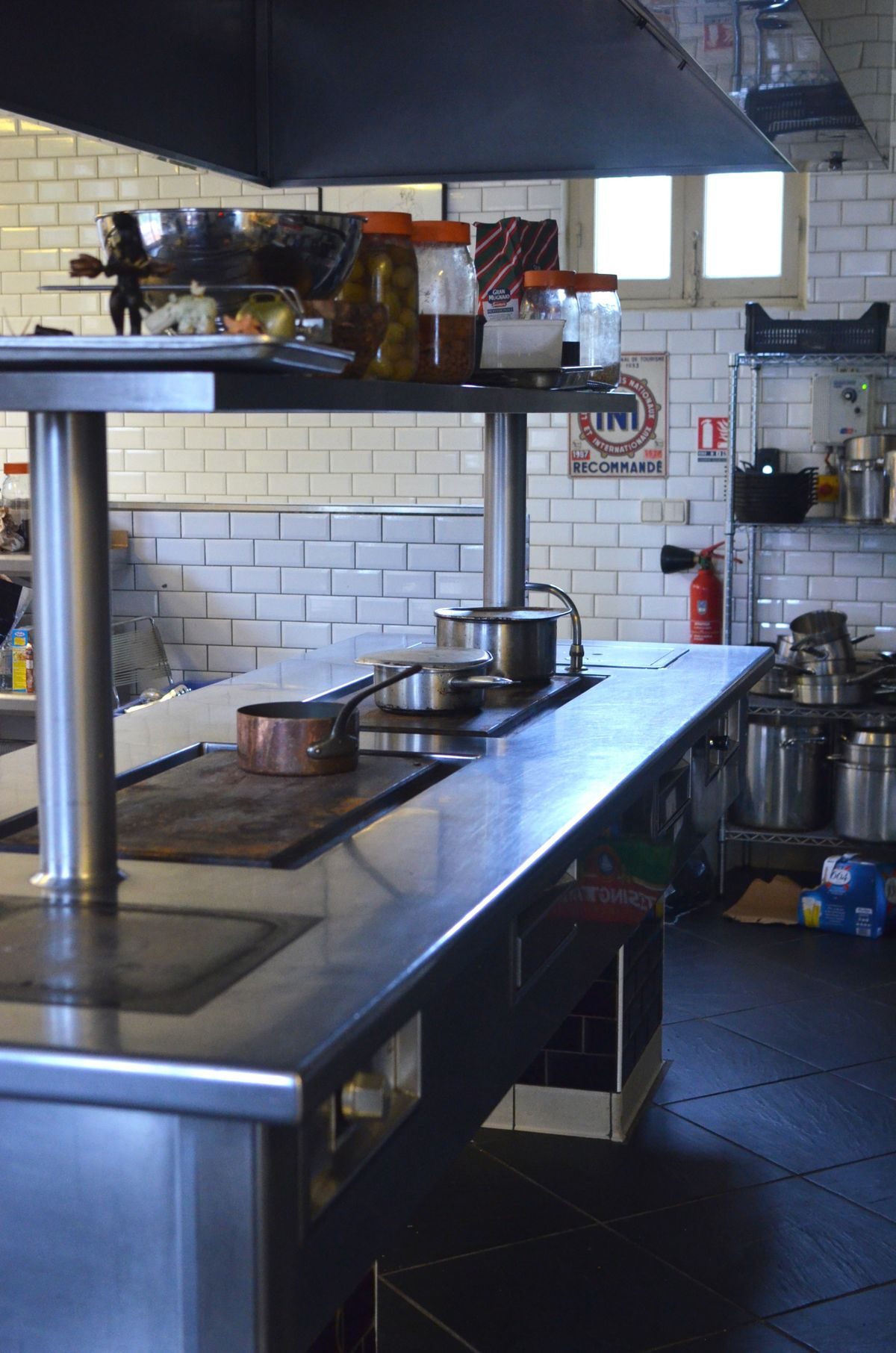 Stainless steel counters, cooktops, and shelving in a commercial restaurant kitchen