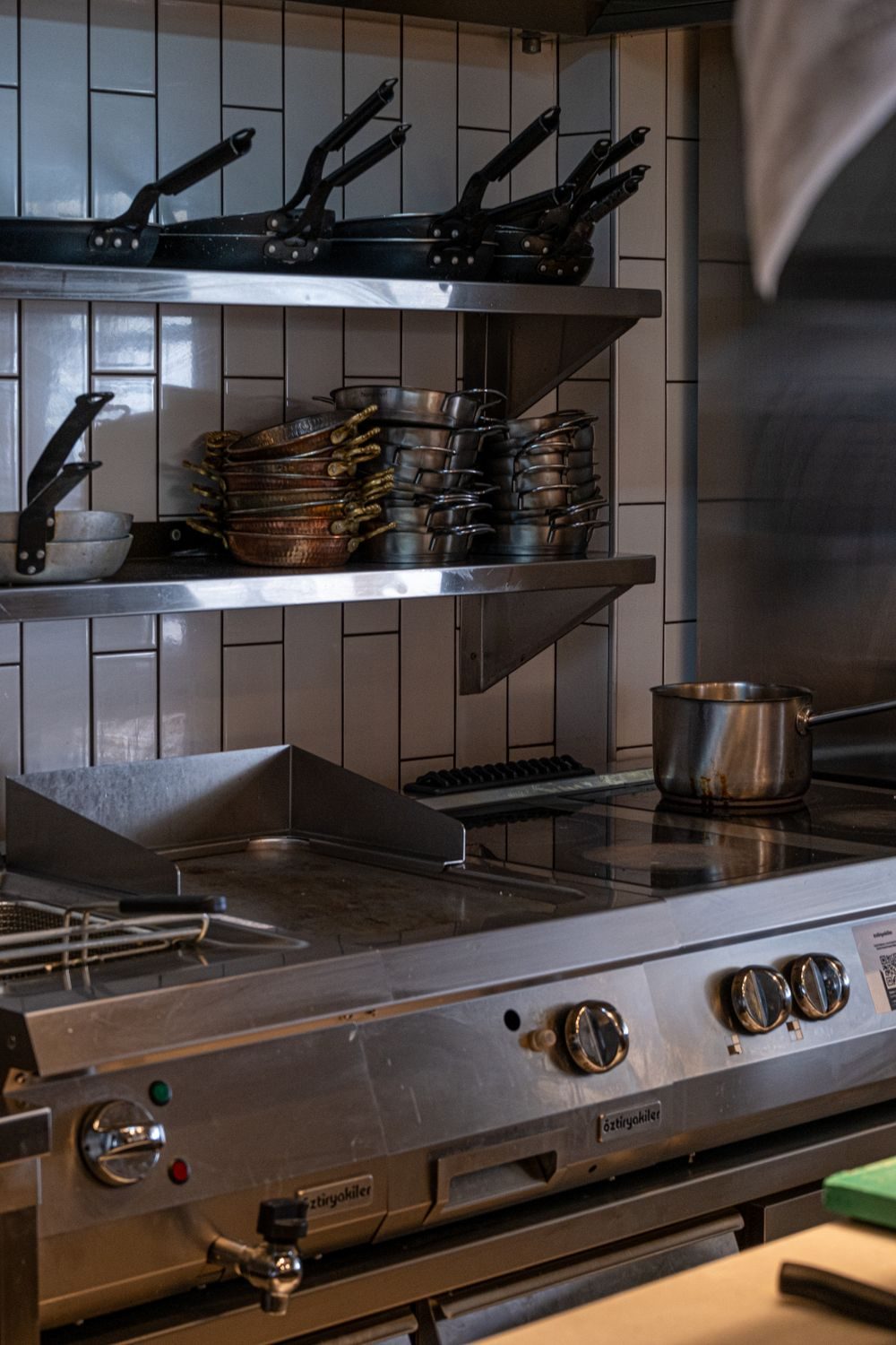 Stacked pans and a cooking range in a commercial restaurant kitchen